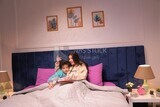 a woman reading a story to her son in bed