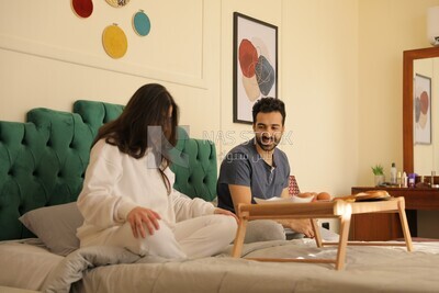 رجل وامراة يتناولان الفطار على السرير 