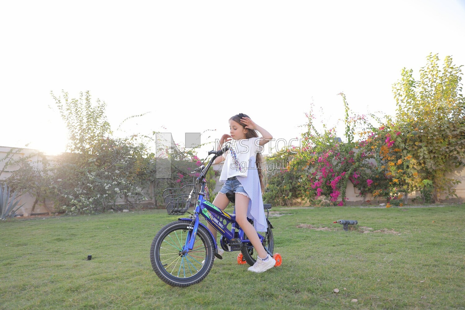 a girl riding a bike in the garden