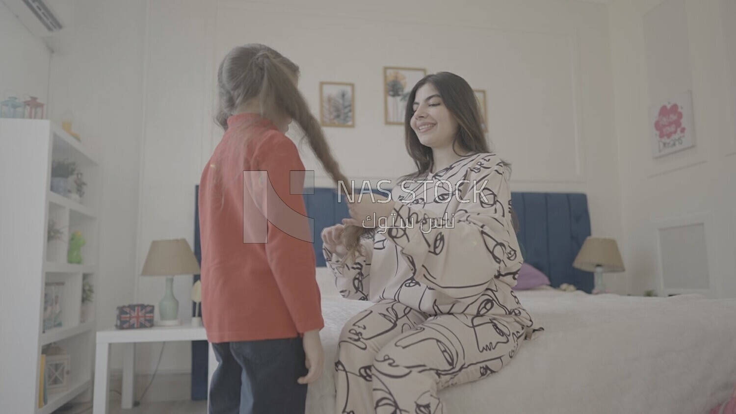 a mother brushes her daughter&#39;s hair