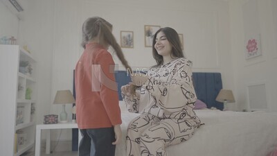 a mother brushes her daughter&#39;s hair