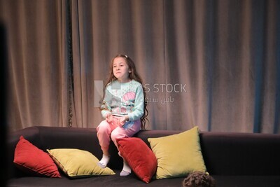 a girl sitting on the sofa in front of the television