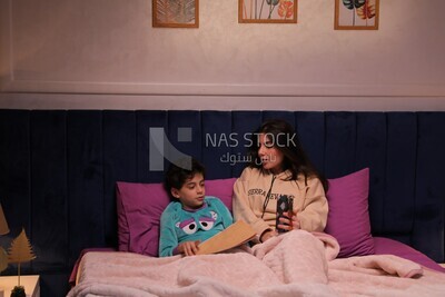 a mother sitting on the phone while her son studies