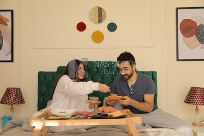 a man and a woman having breakfast on the bed