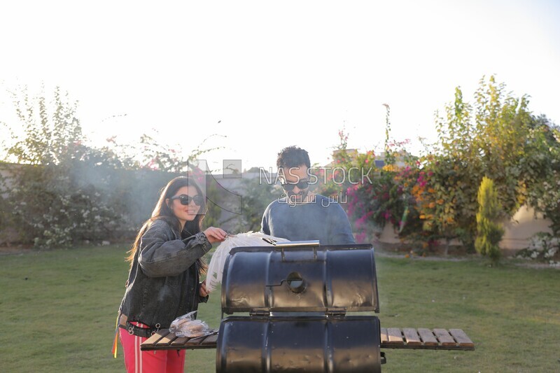 man preparing food on a barbecue grill