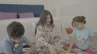 a woman sitting with her children playing