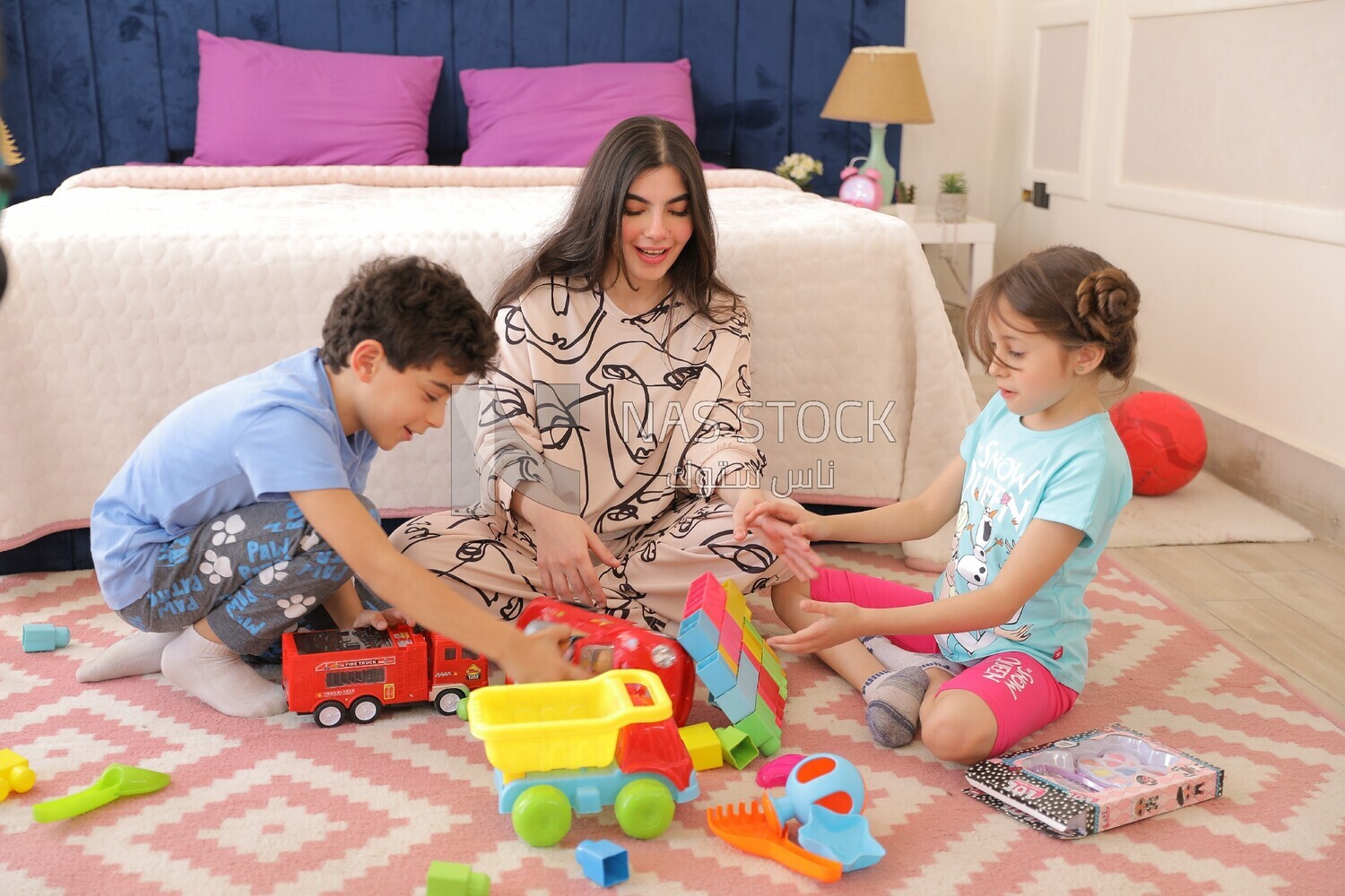 a woman sitting with her children playing