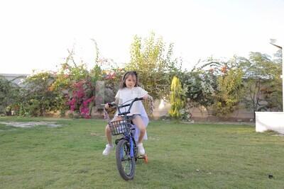 a girl riding a bike in the garden