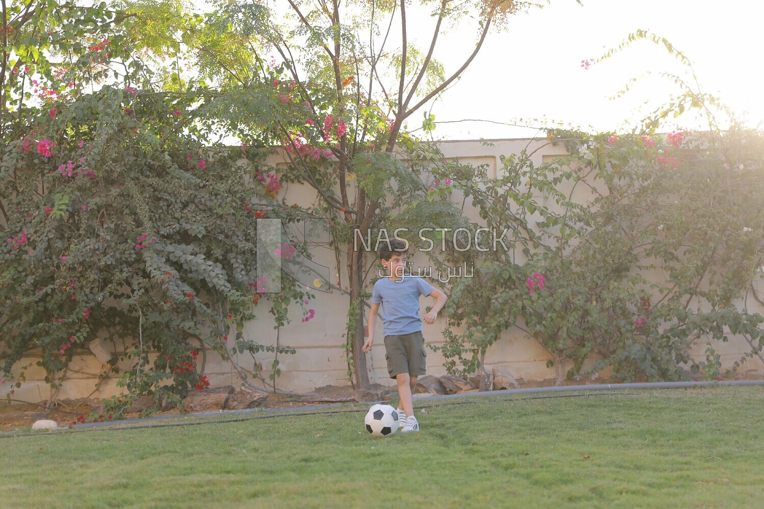 a boy playing football in the garden