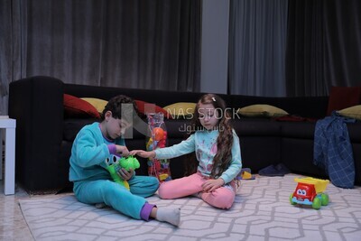 a brother and a sister playing in the living room