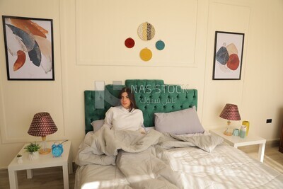 a woman sitting in bed waking up