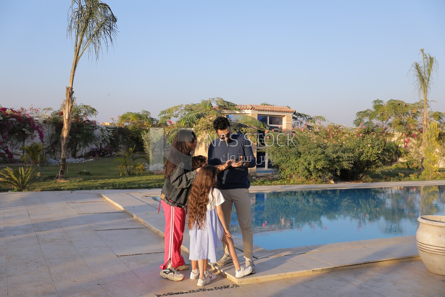 a family of four looking at the phone in the garden