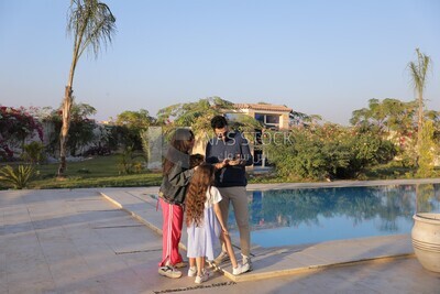 a family of four looking at the phone in the garden