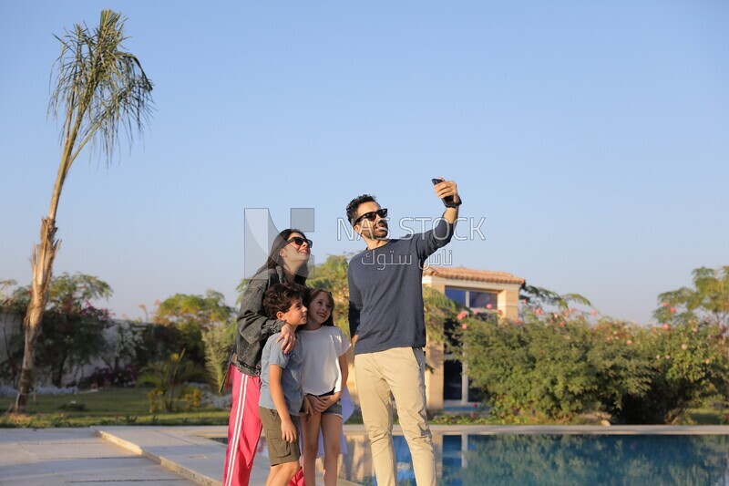 a family of four taking a selfie in the garden