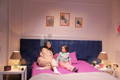 a mother sitting with her daughter and talking in the bed