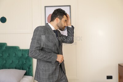 a man wearing a suit standing in front of the mirror