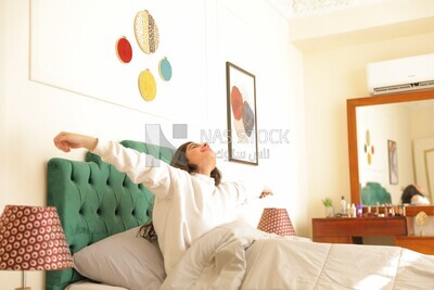 a woman sitting in bed waking up