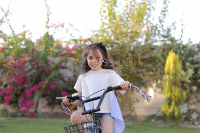 a girl riding a bike in the garden