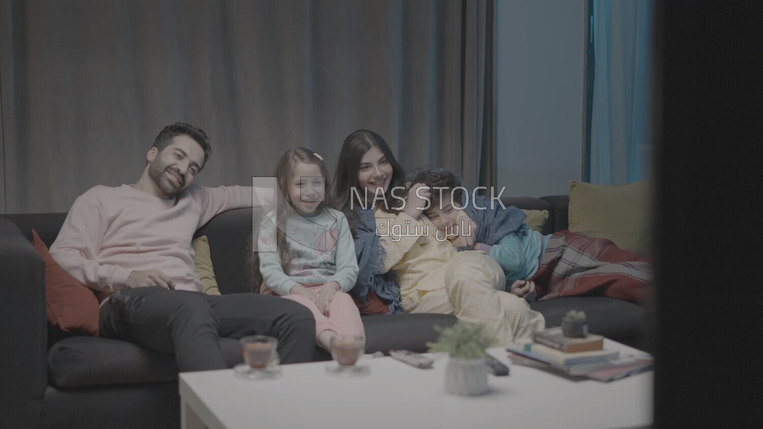 a family of four watching television