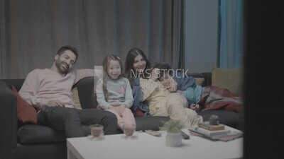 a family of four watching television