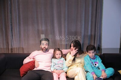 a family of four watching television