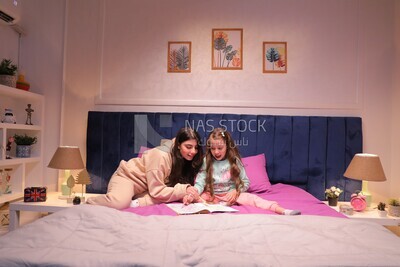 a mother with her daughter drawing together on the bed