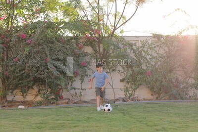 a boy playing football in the garden