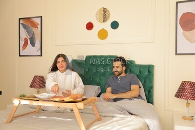 a man and a woman having breakfast on the bed