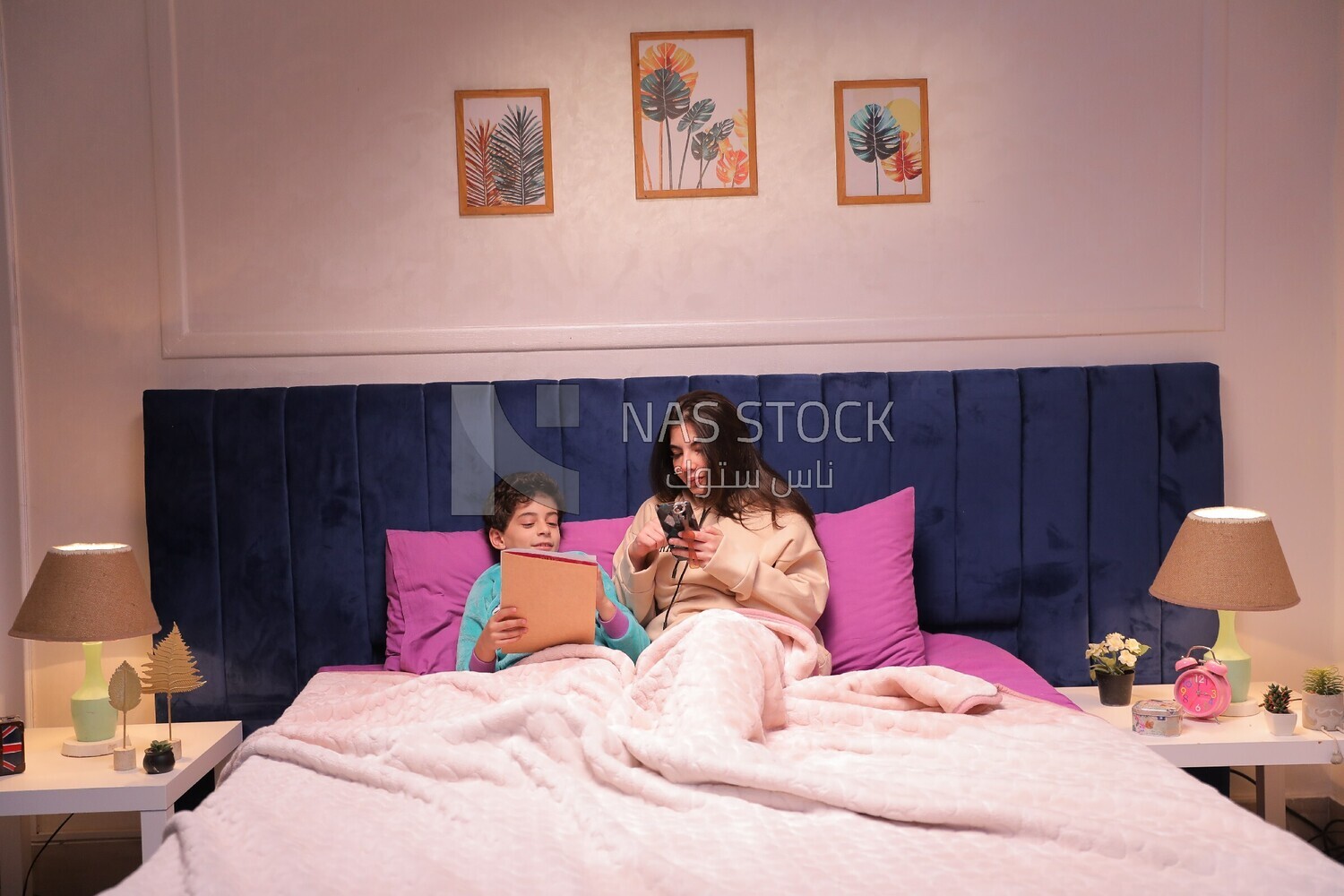 a mother sitting on the phone while her son studies