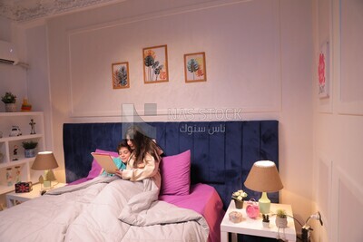 a woman reading a story to her son in bed