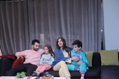 a family of four watching television
