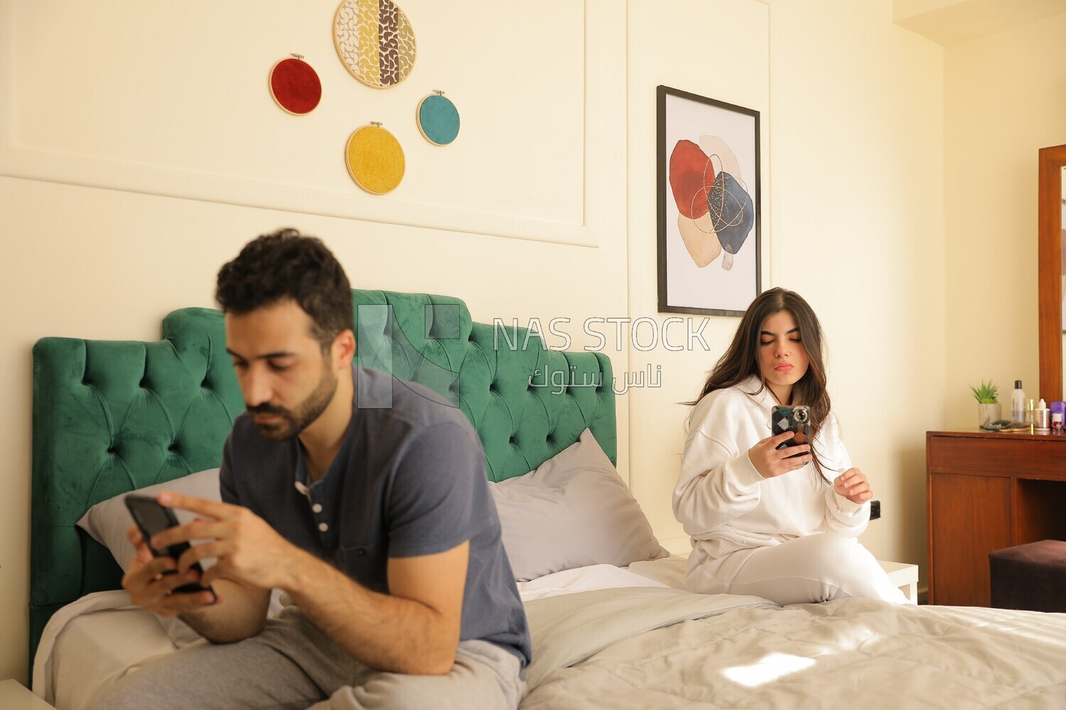 a man texting on the phone while her wife is beside him
