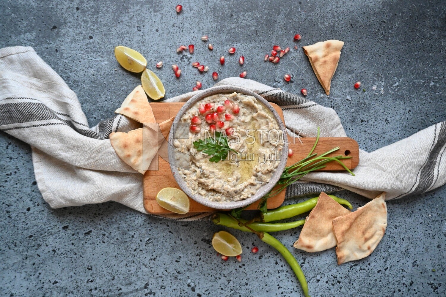 plate of lebanese baba ghanouj with bread and green pepper