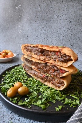 dish with hawawshi next to olive