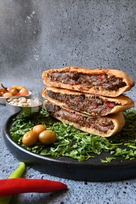 dish with hawawshi next to olive
