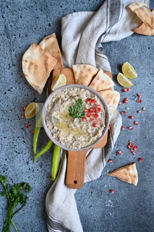 plate of lebanese baba ghanouj with bread and green pepper
