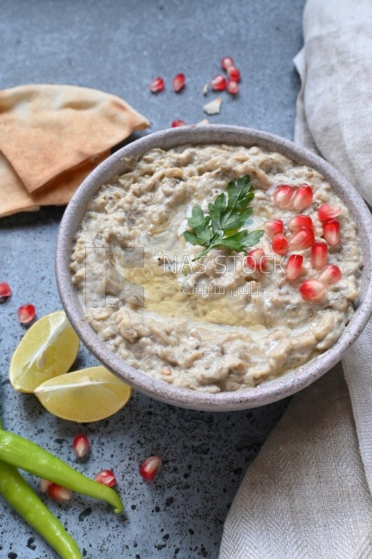 plate of lebanese baba ghanouj with bread and green pepper