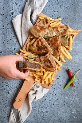 hand holding a hawawshi sandwich