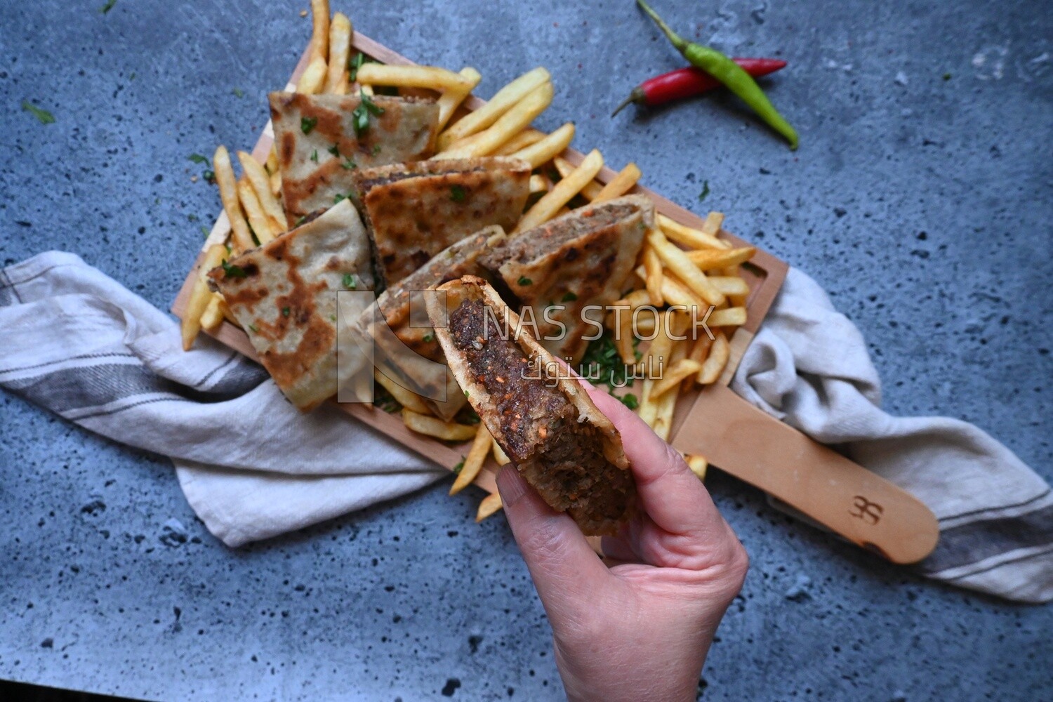 hand holding a hawawshi sandwich