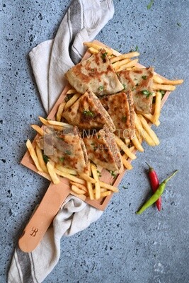 dish with hawawshi next to a spicy pepper and fries.