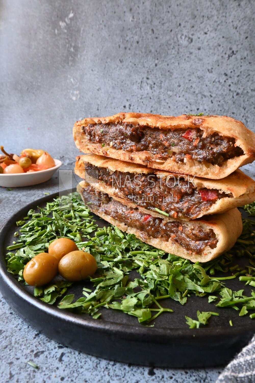 dish with hawawshi next to olive