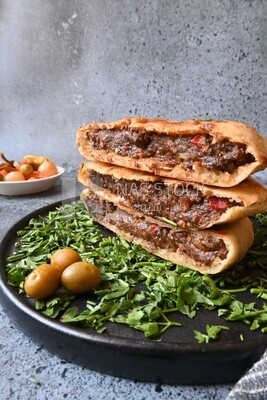 dish with hawawshi next to olive