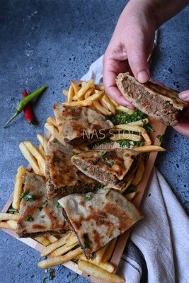 hand holding a hawawshi sandwich