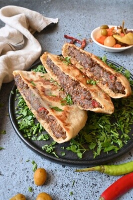 dish with hawawshi next to olive