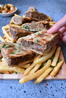 hand holding a hawawshi sandwich