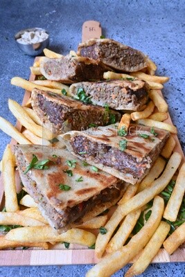 dish with hawawshi on it with fries