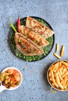 dish with hawawshi next to spicy pepper and fries