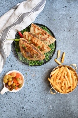 dish with hawawshi next to spicy pepper and fries