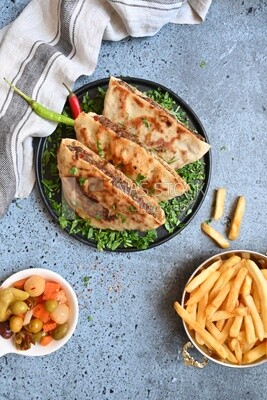 dish with hawawshi next to spicy pepper and fries