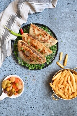 dish with hawawshi next to spicy pepper and fries